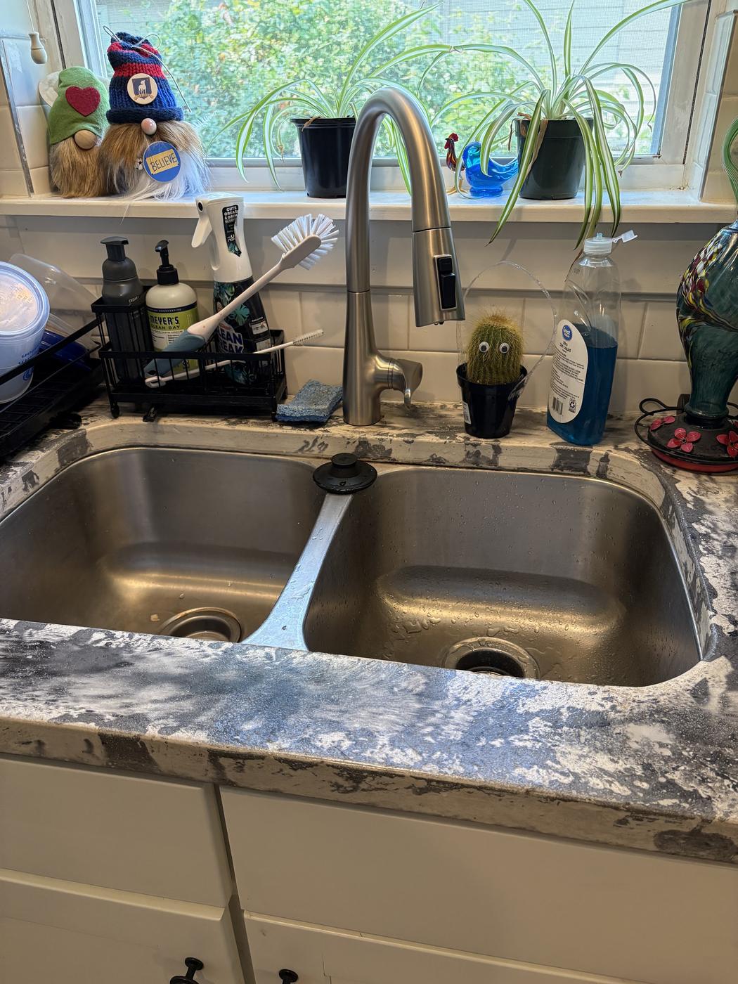 A new pull-down kitchen faucet over an undermount double bowl sink