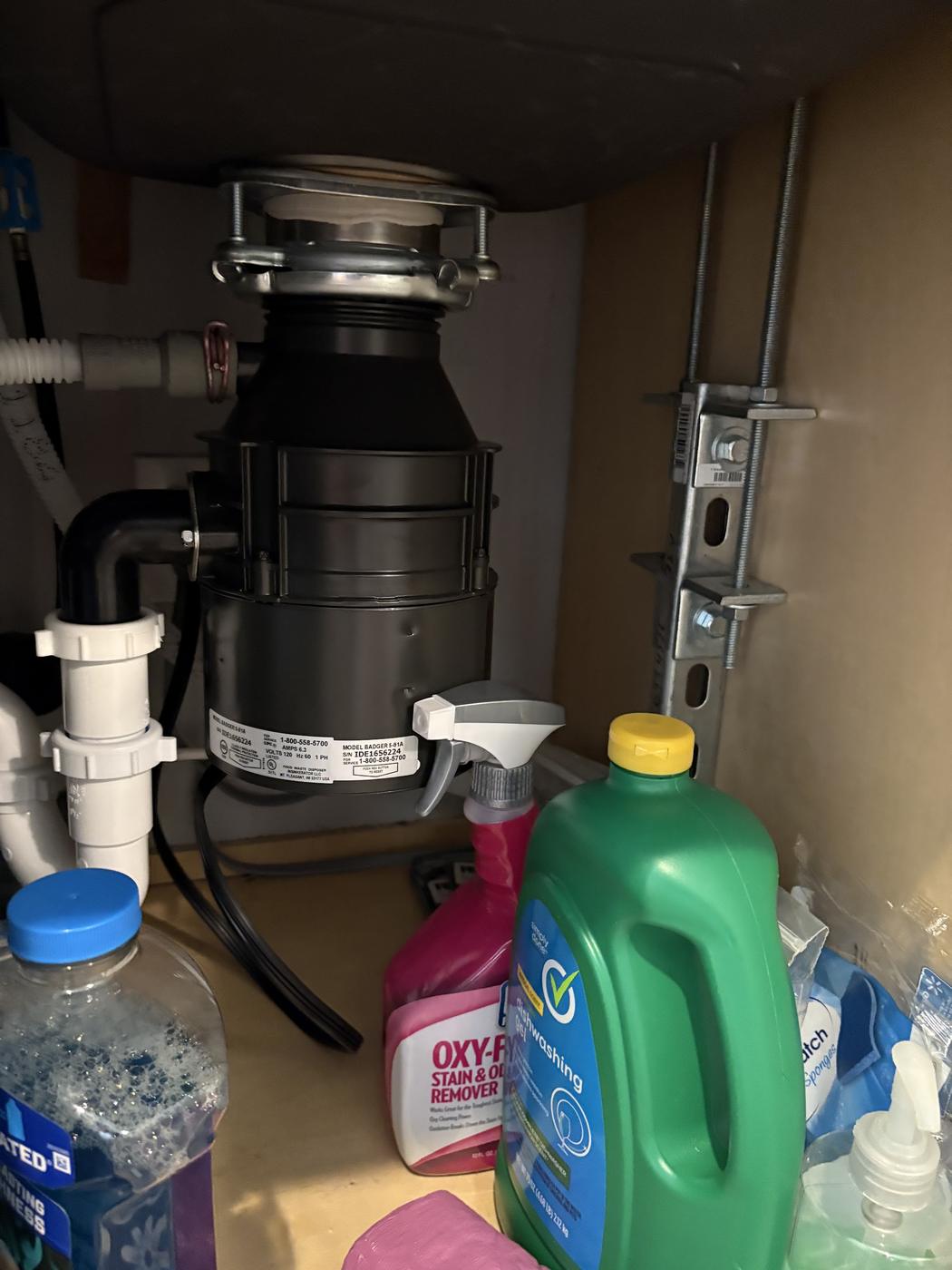 Under a kitchen sink: a newly fitted garbage disposal, new P-trap and dishwasher connection